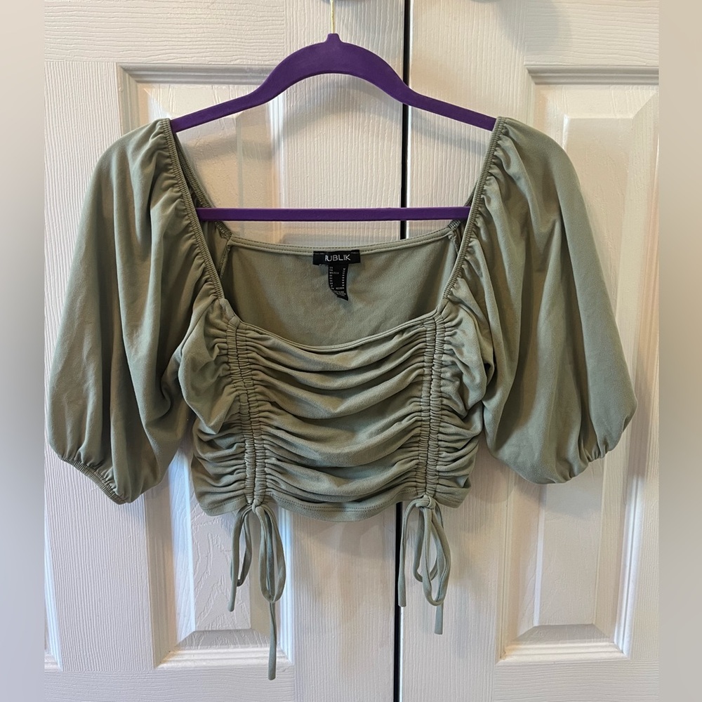Dusty green cropped top with quarter length sleeves and ruched detail.